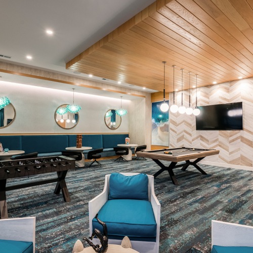 a room with a pool table and chairs